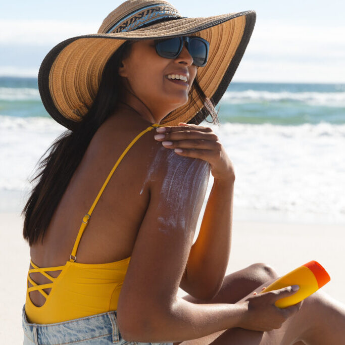 Sunscreen woman on the beach protecting her skin with spf sunscreen